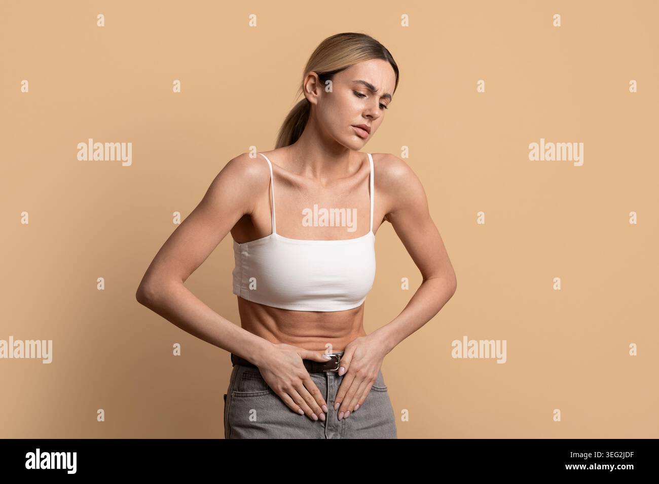 Junge Frau mit Bauchschmerzen und Menstruationskrämpfen Stockfoto