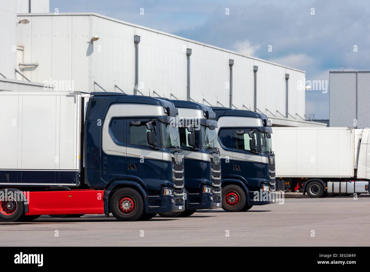 Moderner blauer Frachtwagen Lieferwagen geparktes Logistikzentrum Gebäudekomplex Außenbucht. Auflieger LKW entladen Güterverteilung Stockfoto