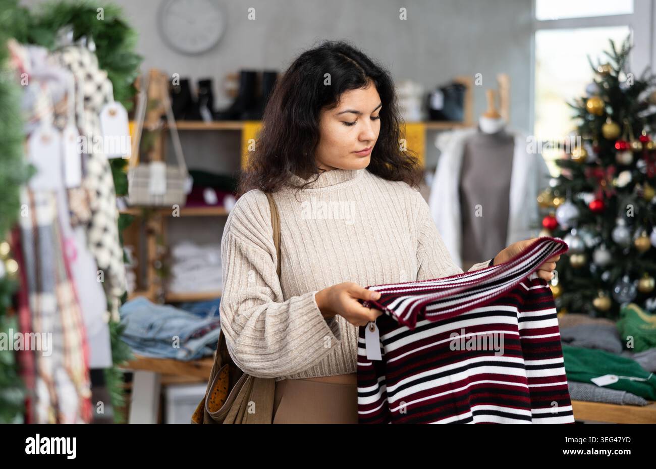 Latina wählt Strickpullover im Geschäft Stockfoto