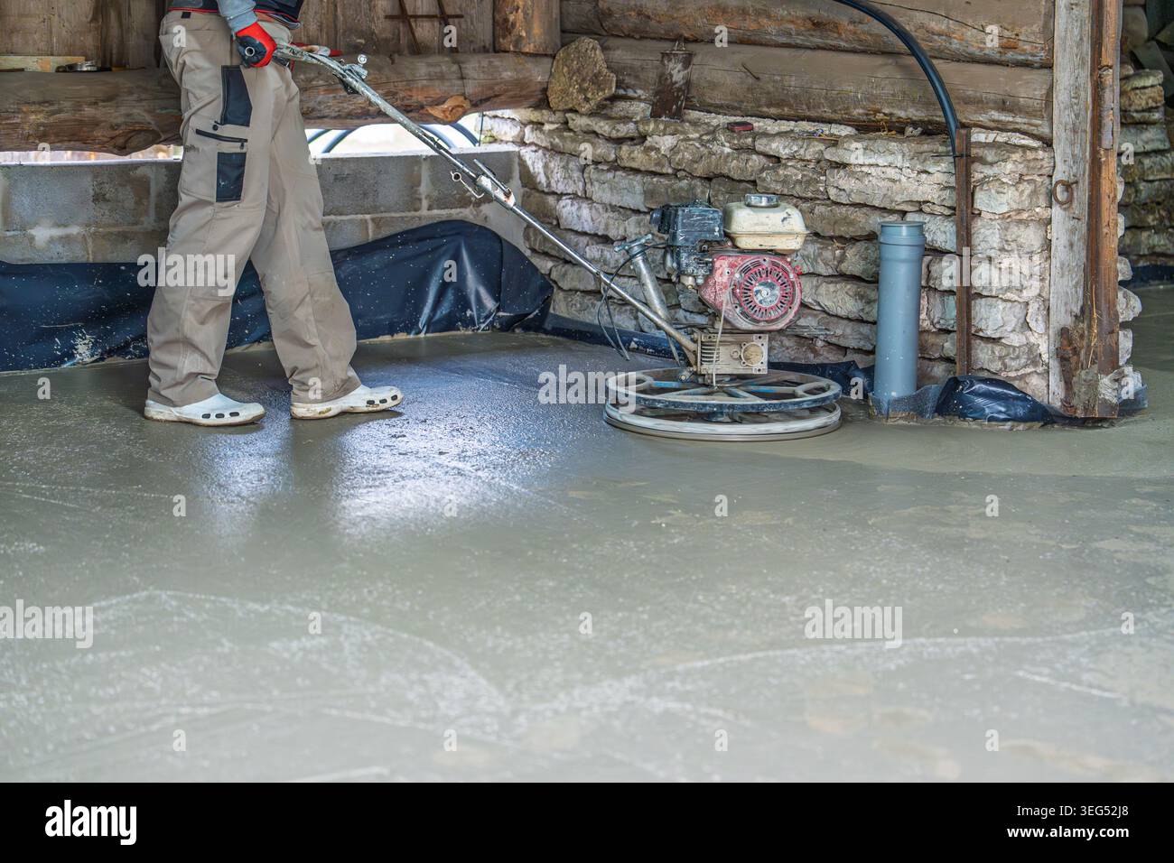 Kraftkelle-Veredelung von Betonboden, Arbeiter glätten Oberfläche mit Maschine in Estland Stockfoto