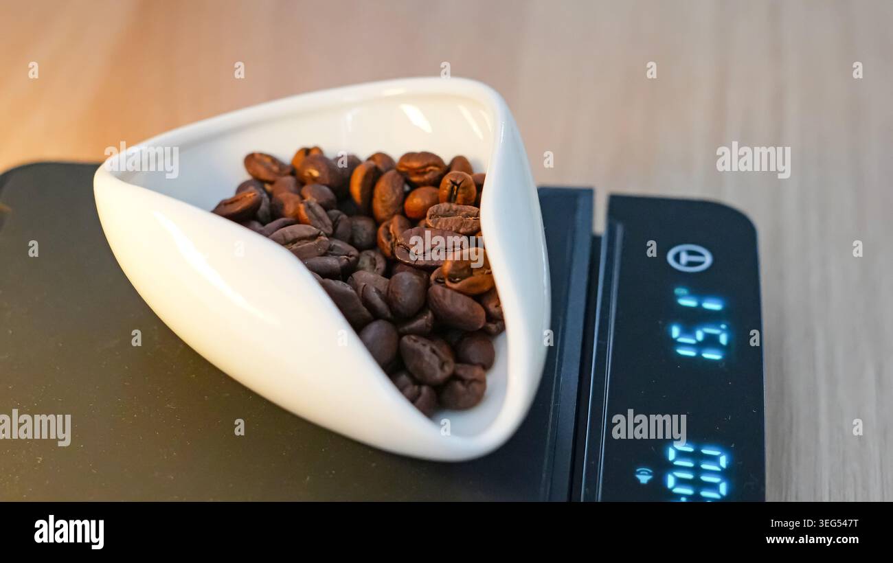 Kaffeebohnen auf digitaler Skala gemessen Stockfoto