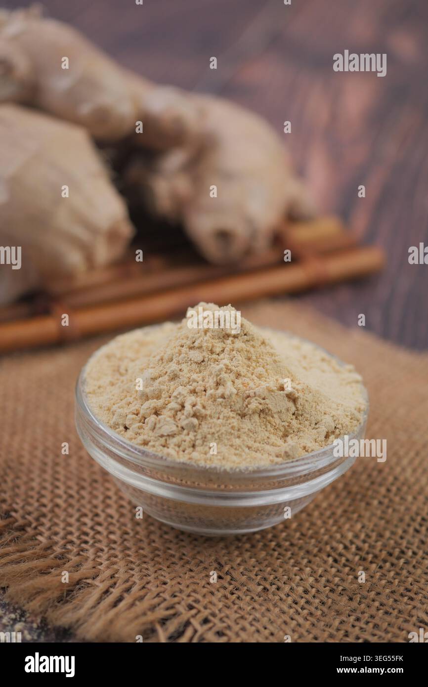 Ingwerpulver in eine Glasschale auf einen Holztisch gelegt Stockfoto