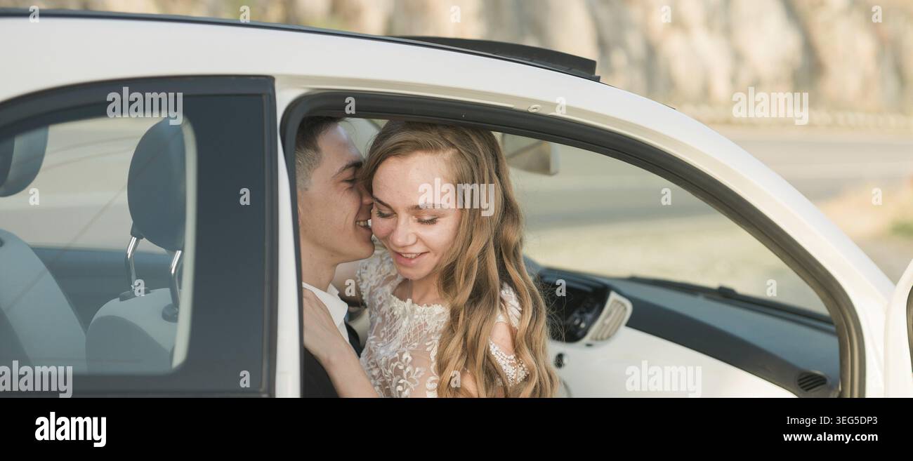 Ein Paar teilt sich den zärtlichen Moment im geparkten Auto während Sonnenuntergang. Liebe, Verbindung, Intimität und friedliche Freude in einer offenen romantischen Umarmung Stockfoto