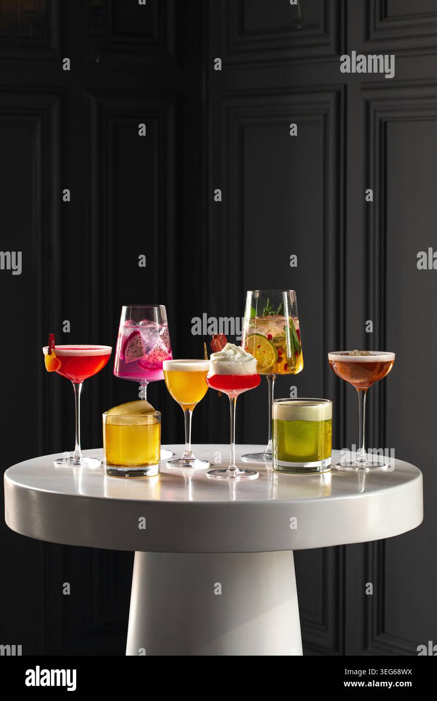 Farbenfrohe Cocktails auf elegantem weißen Tisch Stockfoto