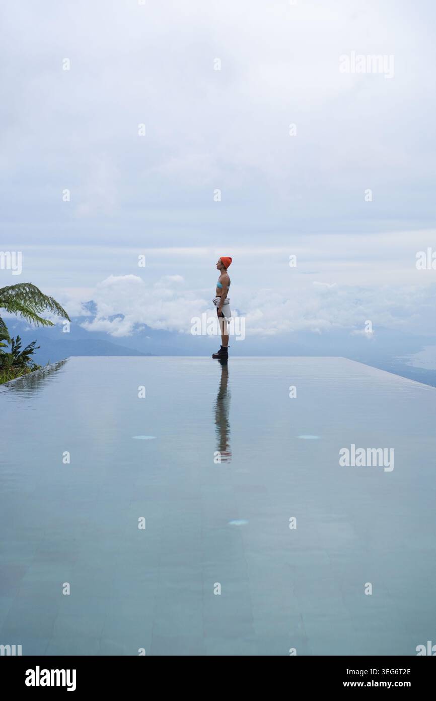 Eine junge Frau, die in den Himmel am Infinity Pool schaut, Munduk, Bali Stockfoto