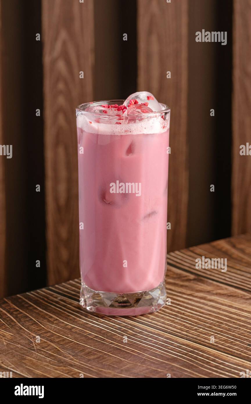 Gefrorener rosafarbener Latte mit Himbeerstückchen auf Holz Stockfoto