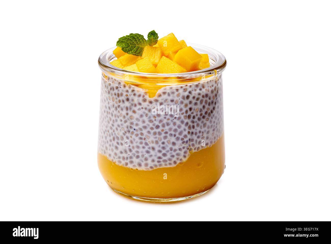 Cremiges Mango-Chia-Dessert. Nahaufnahme eines lebhaften Mango-Chia-Pudding mit Kokos- und Minzgarnituren Stockfoto
