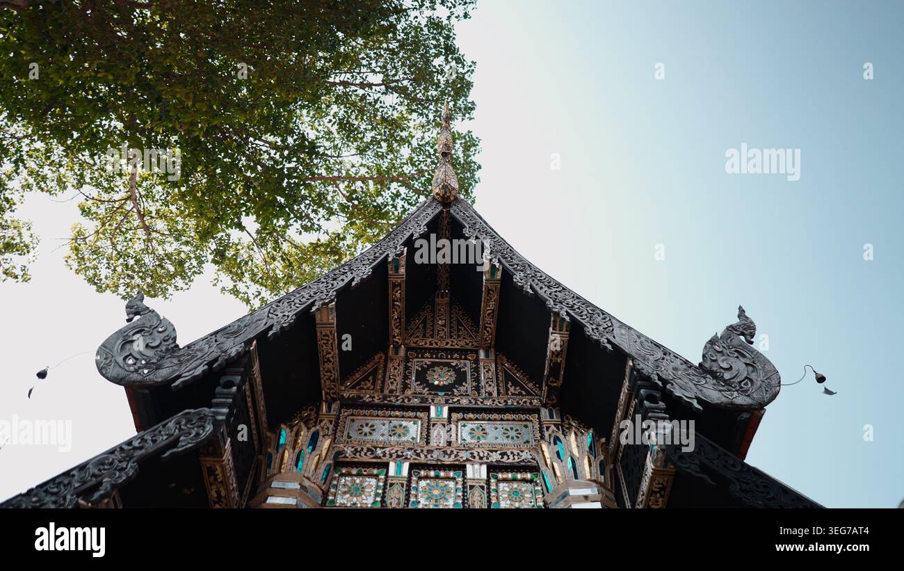Kunstvolle Holzschnitzereien auf dem Dach und der Fassade des antiken thailändischen Tempels gegen den Himmel Stockfoto