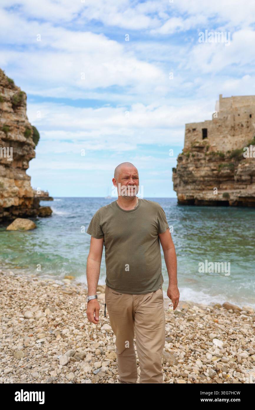 Touristen posieren am Meer in einem wunderschönen Küstendorf mit dramatischen Klippen, türkisfarbenem Wasser und authentischer Reisetmosphäre. Stockfoto