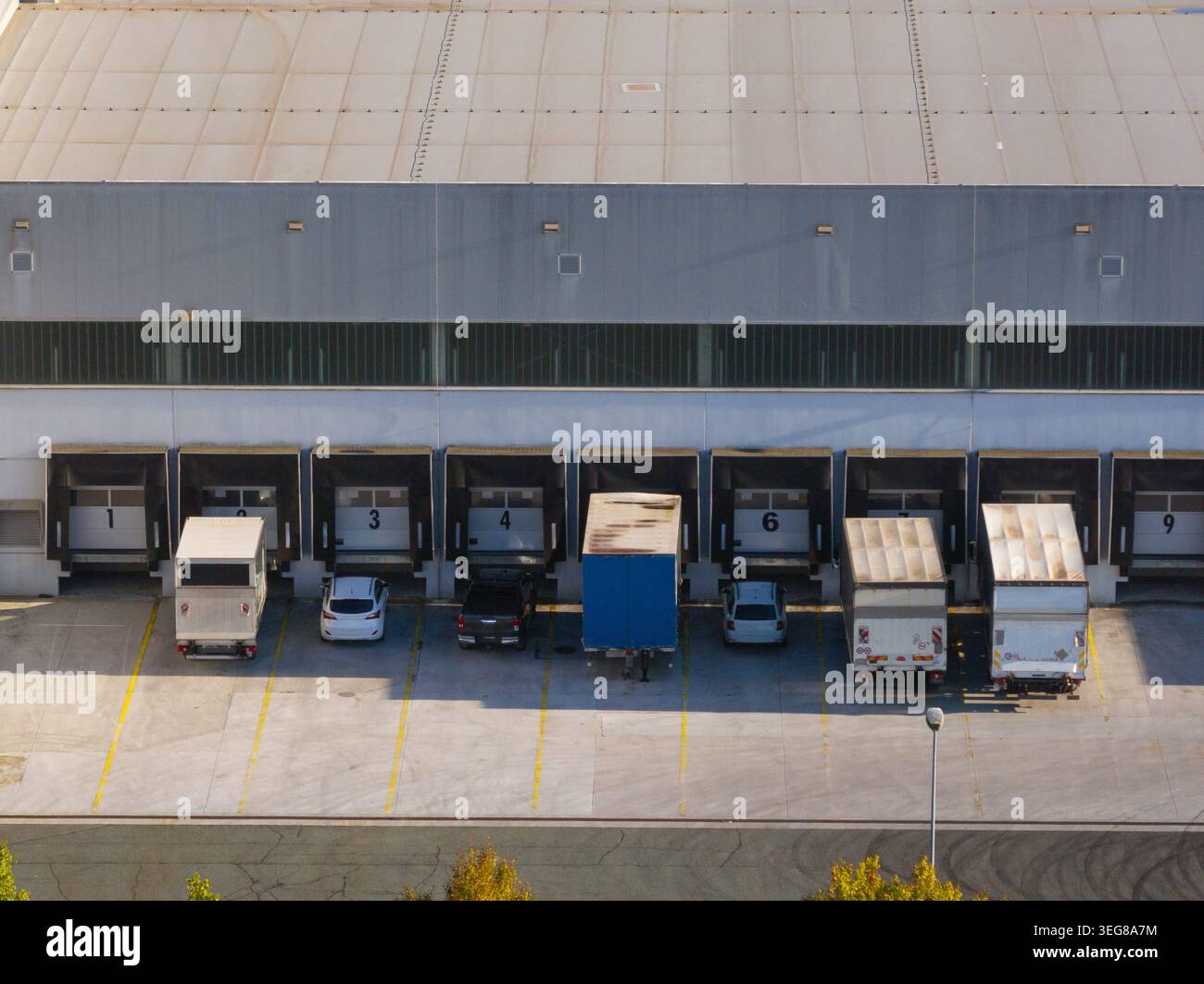 Güterwagen werden an den Laderampen in einem Logistikzentrum für die Ladungsverteilung und den Betrieb der Lieferkette abgestellt. Stockfoto