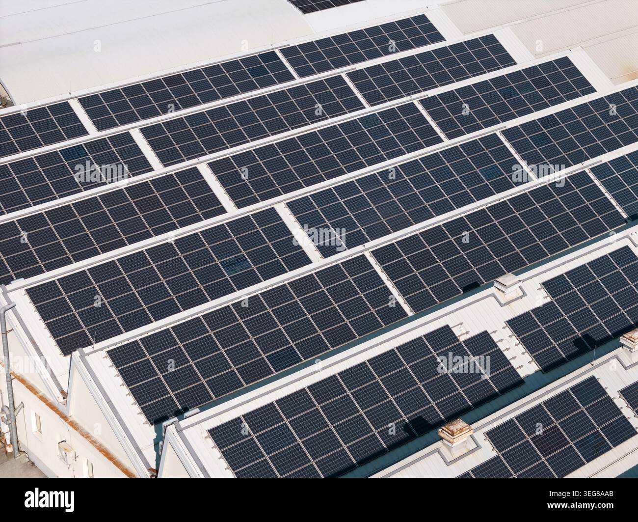 Solarpaneele werden auf Dächern in einem Solarstandort installiert, in dem tagsüber erneuerbarer Strom in Industriegebäuden erzeugt wird. Stockfoto