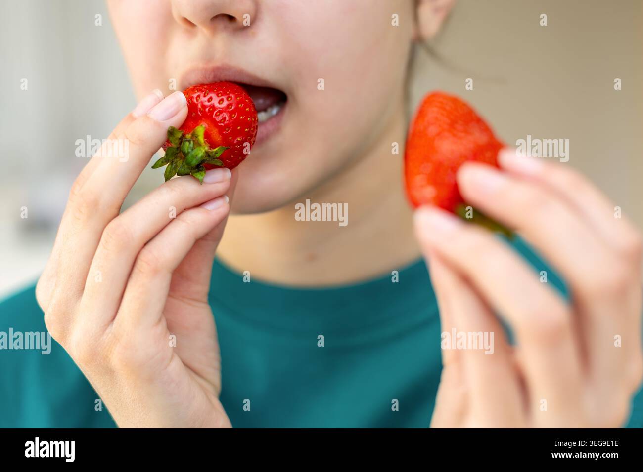 Jemand Isst Frische Erdbeeren Aus Nächster Nähe. Nahaufnahme einer Person, die frische Erdbeeren isst, zeigt gesunde Snacks, süße Früchte, und natürlich jeden Tag Stockfoto