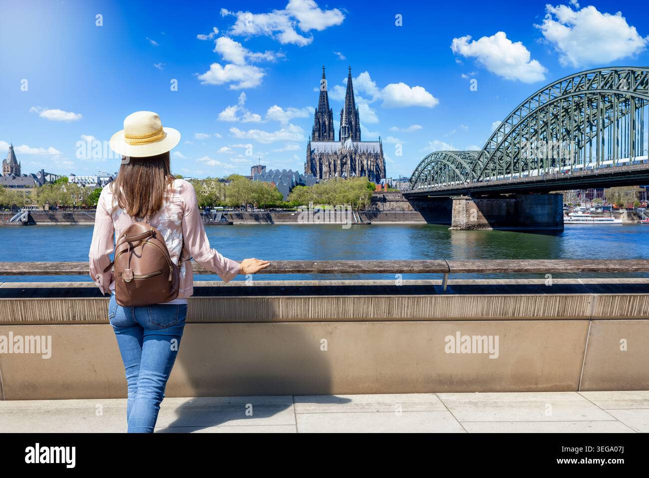 Eine Touristenfrau schaut auf den Rhein und die Kölner Kathedrale während ihrer Stadtrundfahrt Stockfoto