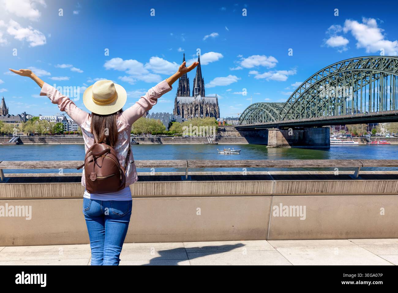 Eine glückliche Touristin schaut während ihrer Stadtrundfahrt auf die Skyline von Köln, Deutschland Stockfoto
