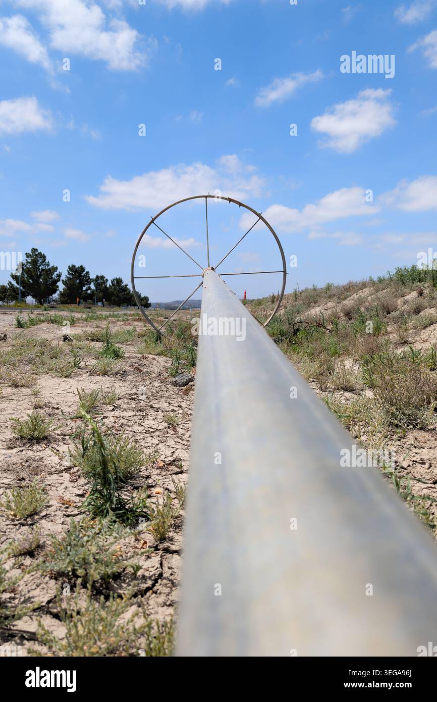 Perspektivische Ansicht Von Der Landwirtschaftlichen Bewässerungsleitung Zum Rad Stockfoto