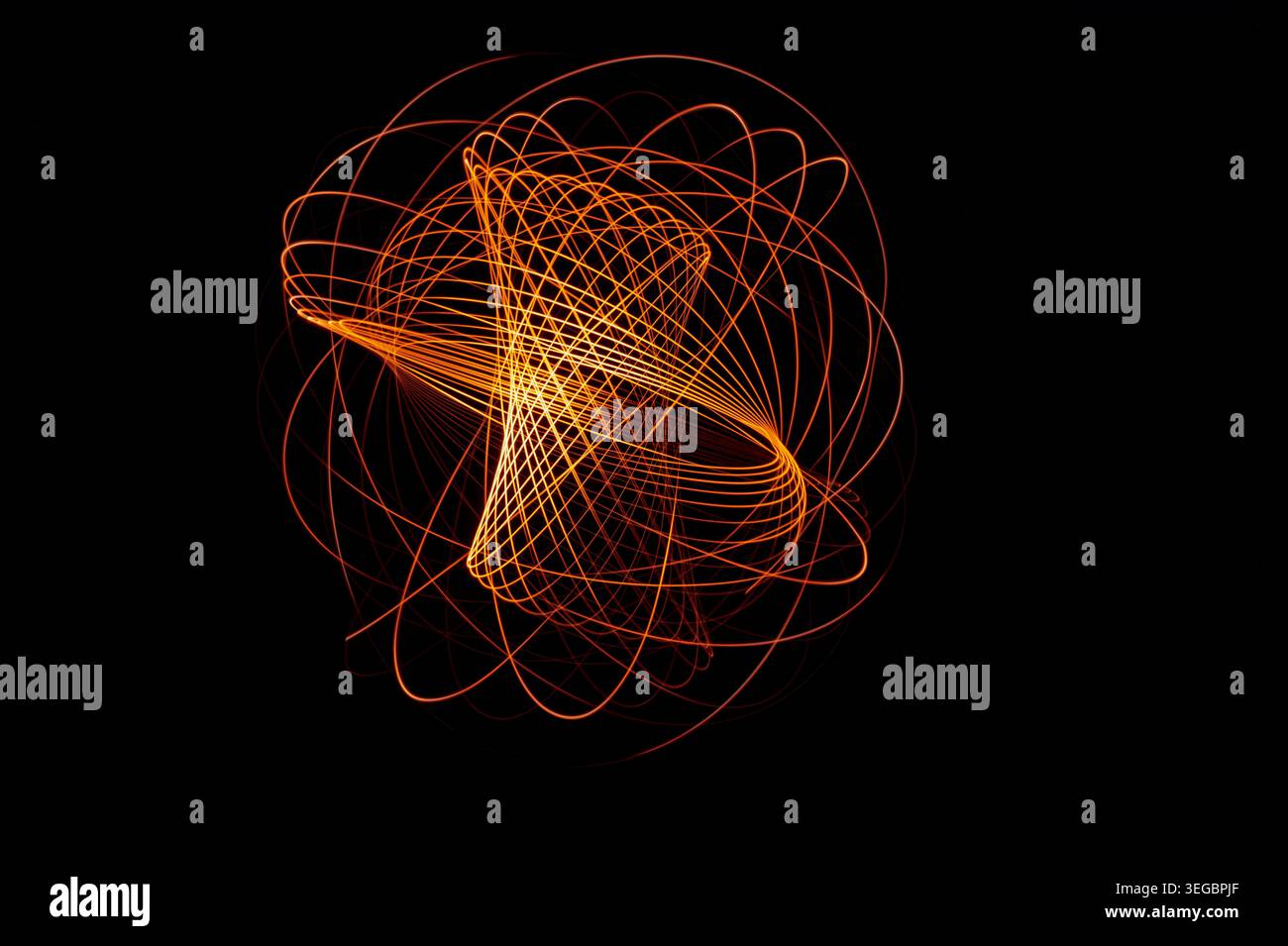 Abstrakte, lange belichtete Lichtmalerei mit leuchtenden orange- und roten Lichtspuren, die komplexe geometrische Kurven vor tiefschwarzem Hintergrund bilden Stockfoto