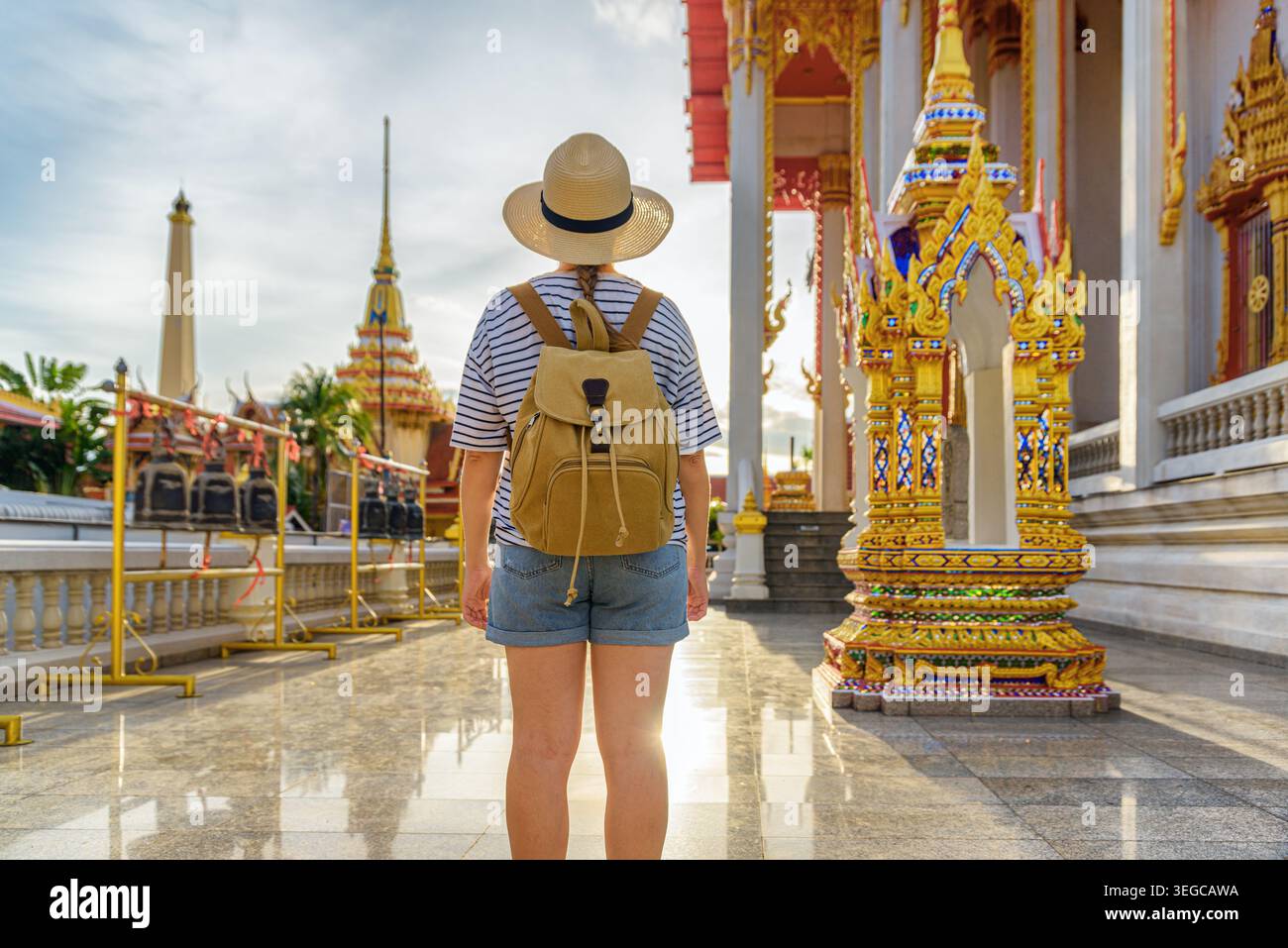 Weibliche Touristin mit Hut und Rucksack in einem buddhistischen Tempel Stockfoto