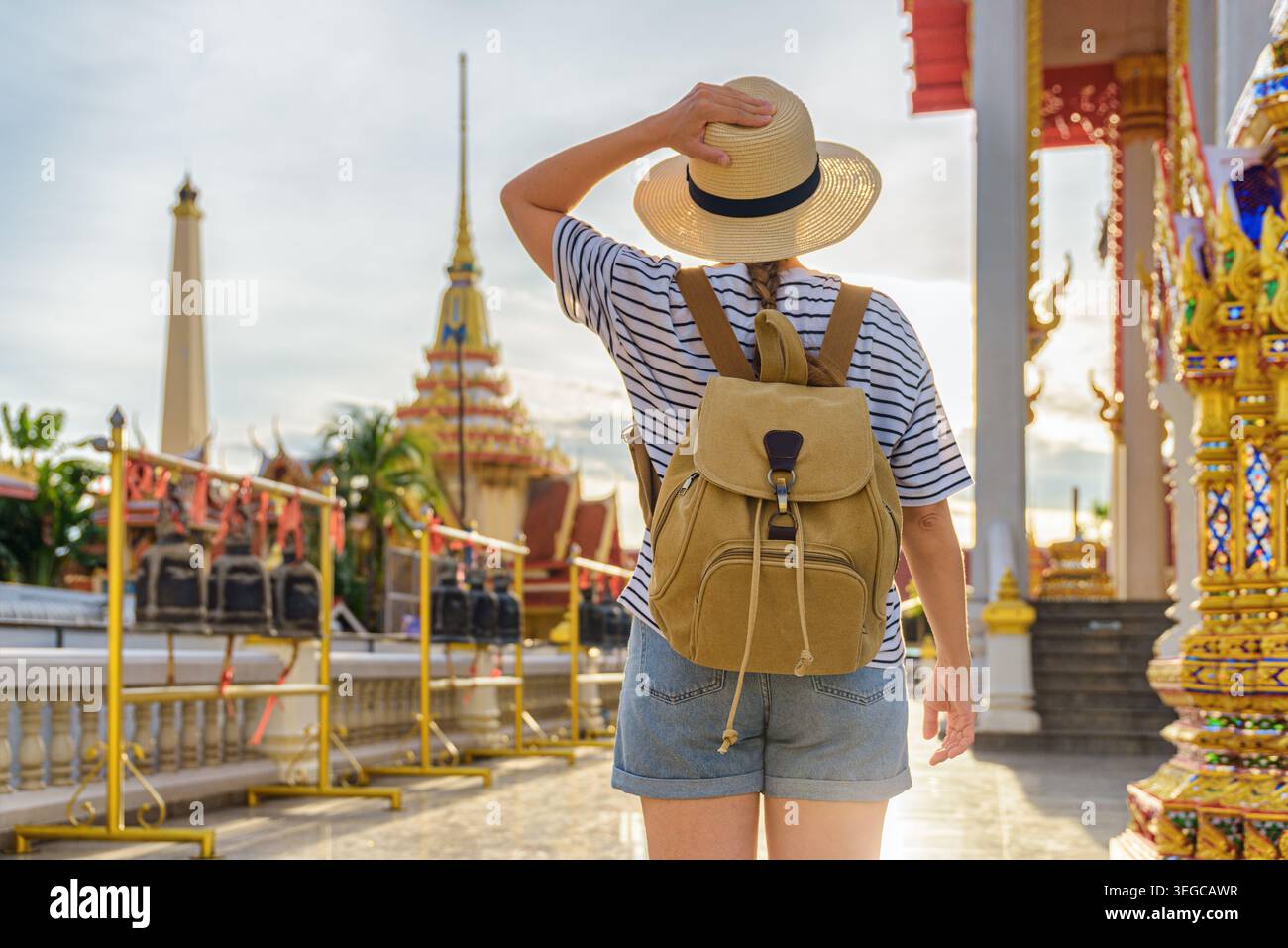 Weibliche Touristin mit Hut und Rucksack in einem buddhistischen Tempel Stockfoto