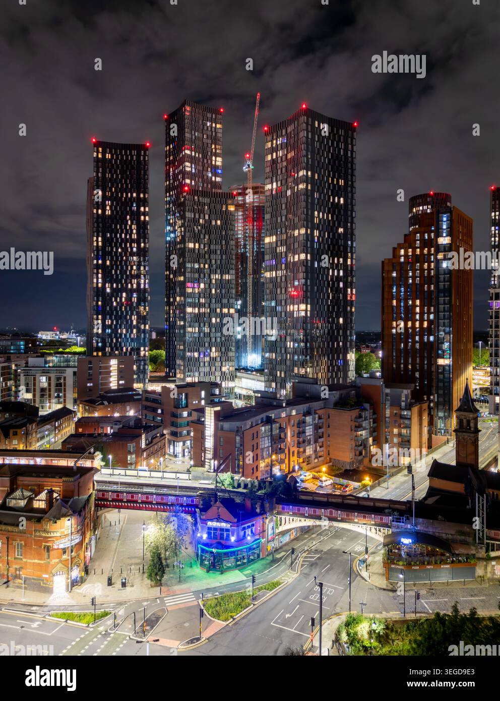 Stadtzentrum von Manchester bei Nacht mit einer beleuchteten Skyline, die den Beetham Tower, Deansgate Square und moderne Architektur im Nordwesten Englands zeigt. Stockfoto