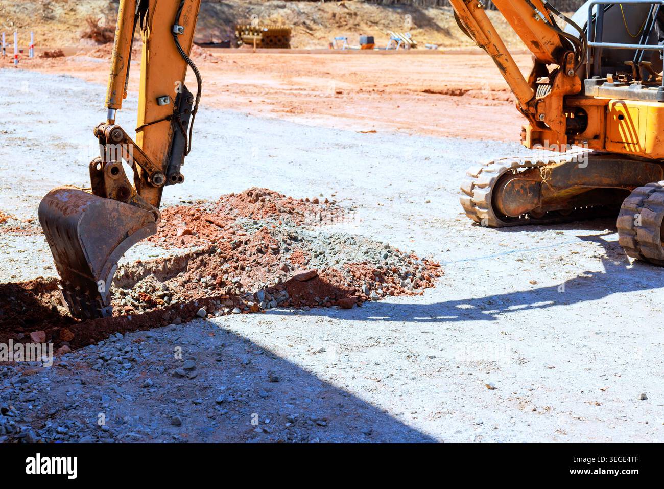Der Bagger arbeitet beim Ausgraben von Boden zum Graben auf der Baustelle Stockfoto