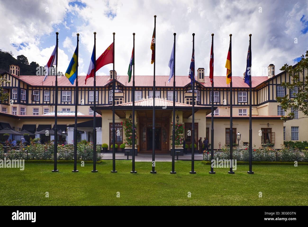 Haupteingang des Grand Hotels, Nuwara Eliya, Sri Lanka - Tudor-Stil mit internationalen Flaggen im Garten Stockfoto