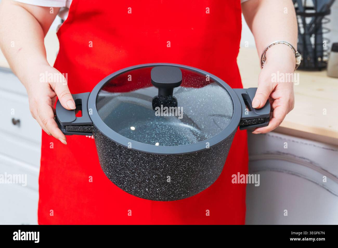 Demonstration Eines Robusten Küchentopfes Mit Ergonomischen Griffen Und Warmer Kochatmosphäre Stockfoto