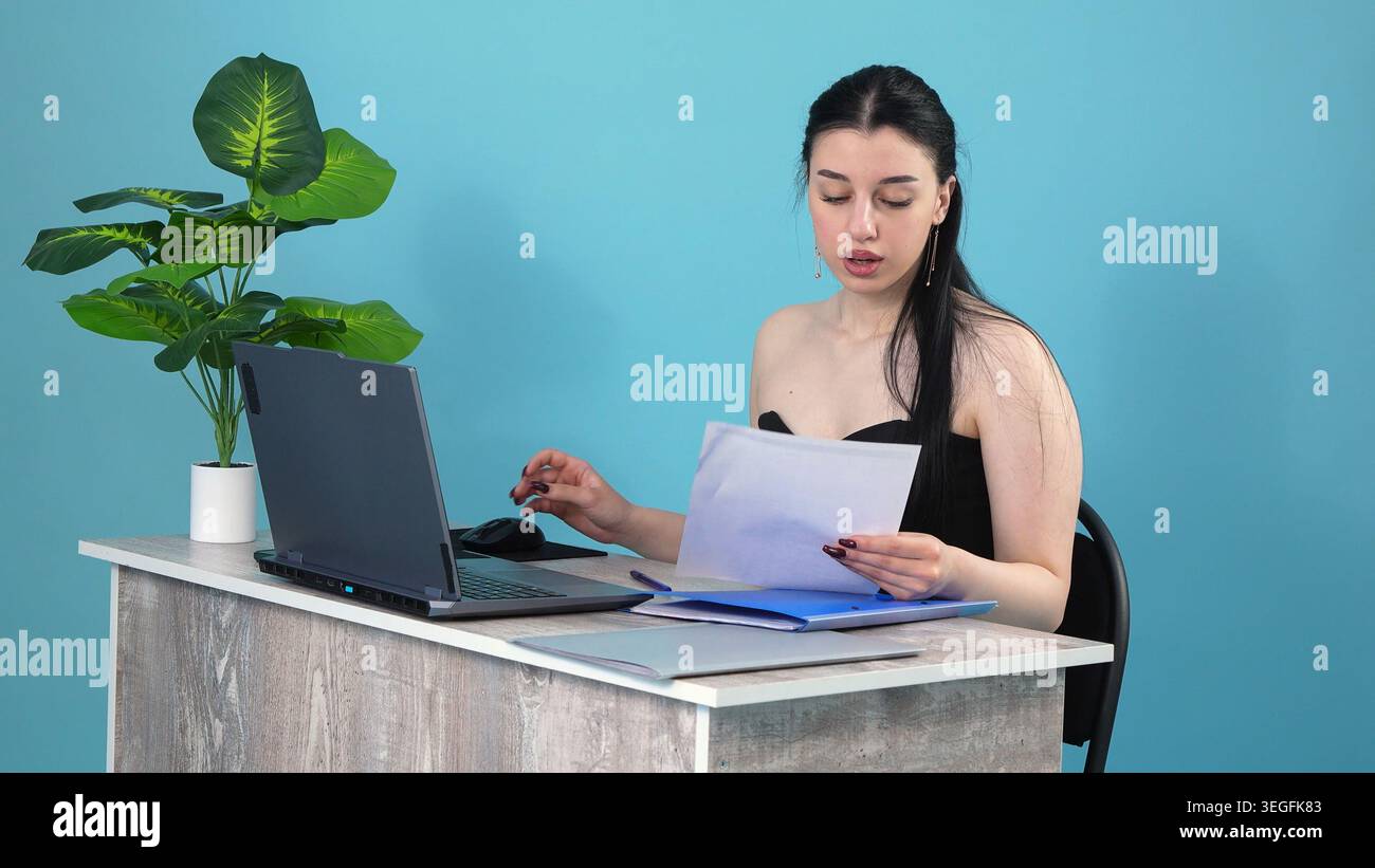 Konzentrierte Geschäftsfrau, die Berichte am Schreibtisch liest Stockfoto