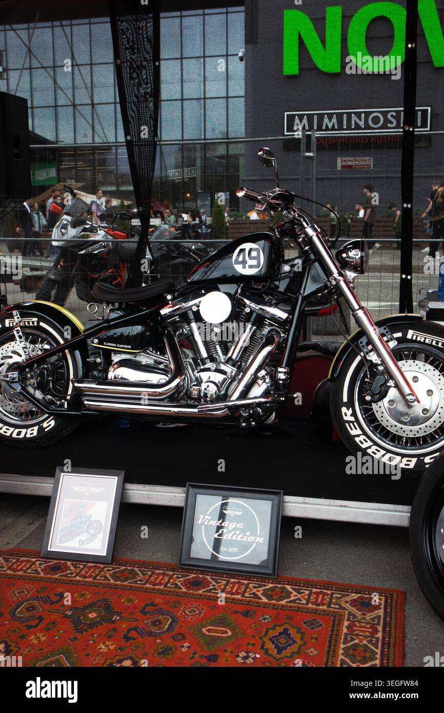 Black Cruiser In Innenräumen Hervorgehoben. Sammler, Der Fotos Von Classic Black Motorrad Im Display Aufnimmt Stockfoto