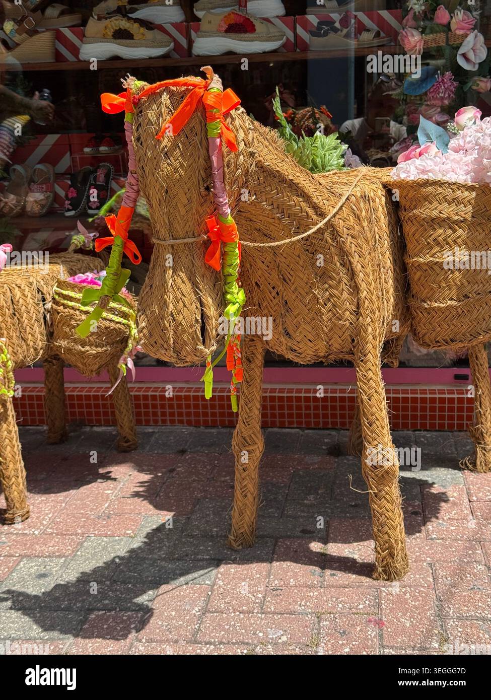 Eine lebensgroße dekorative Pferdefigur, gewebt aus natürlichem Stroh und Korbgeflecht, ausgestellt vor einem Souvenirladen in Curacao. - Smartphone-aufgenommenes Stockfoto
