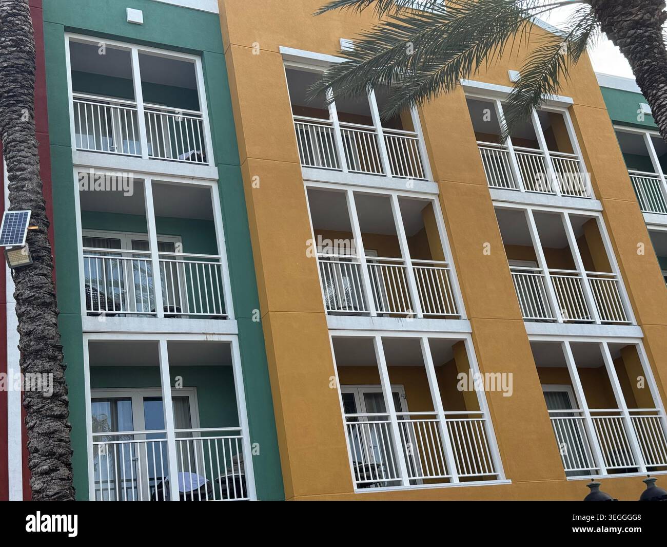 Traditionelle farbenfrohe niederländische Kolonialarchitektur und hohe Palmen vor blauem Himmel im Zentrum von Willemstad, Curacao. - Smartphone-aufgenommenes Stockfoto