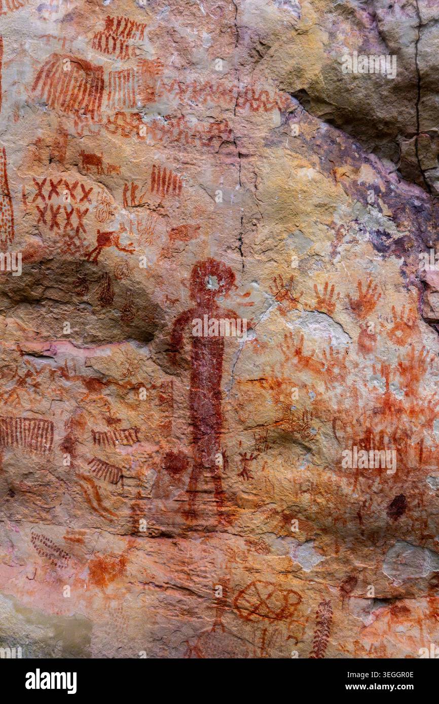 Antike Piktogramme auf Felsoberfläche, die menschliche Figuren und abstrakte Symbole darstellen. Stockfoto