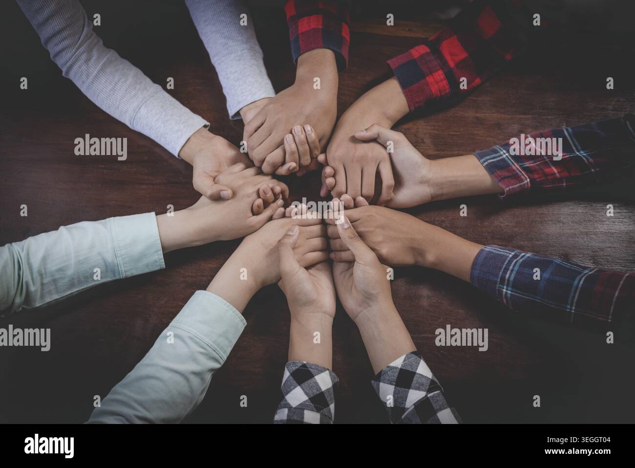 Gruppe von Christen verschiedene Hände halten die Hände im Kreis, um für Gott zu beten, und unterstützen gemeinsam die Teamarbeit. Draufsicht. Stockfoto
