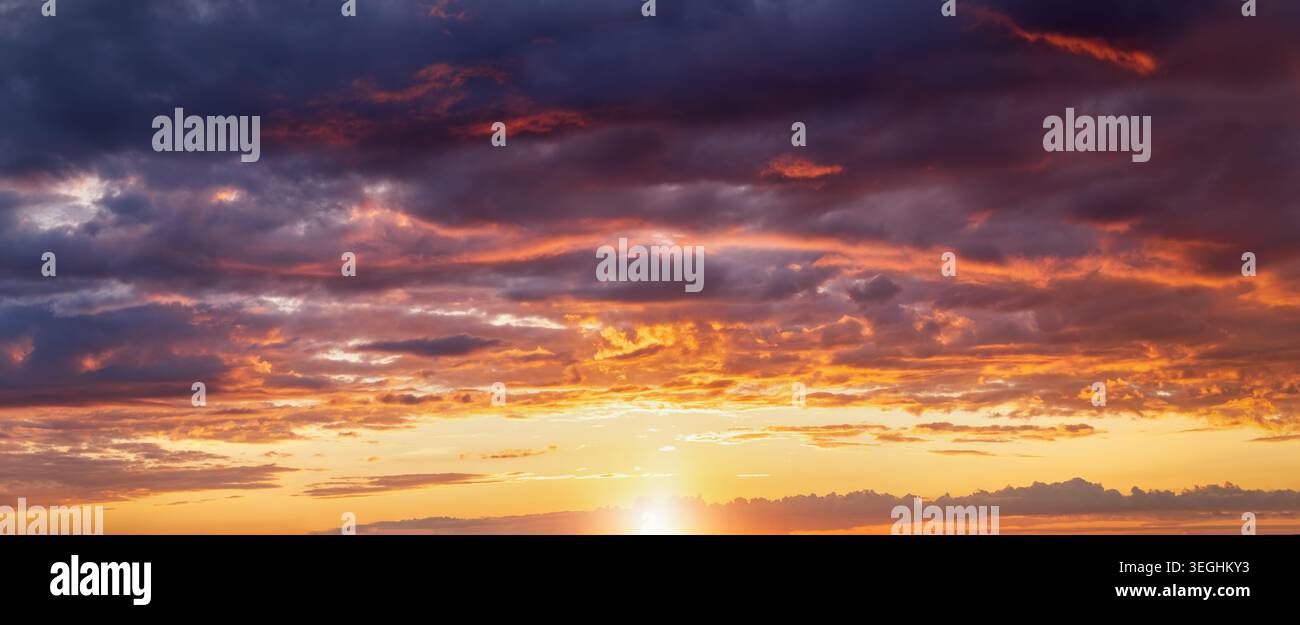 Panorama eines dramatischen Sonnenuntergangs Himmel mit orange und rosa Wolken und Licht als Hintergrund oder Textur Stockfoto