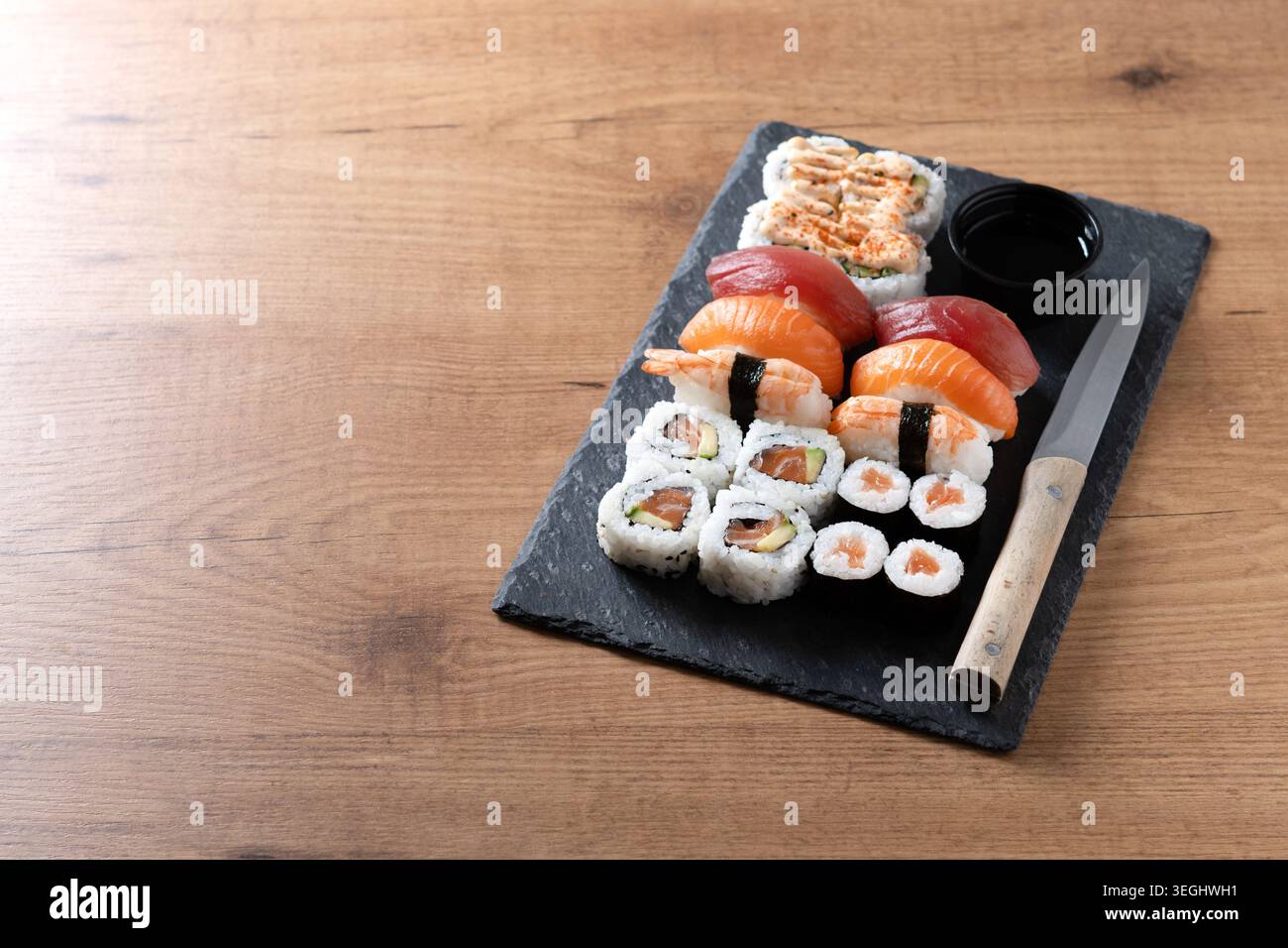 Frische Sushi-Auswahl mit Lachs Maki und Nigiri auf Holztisch Stockfoto