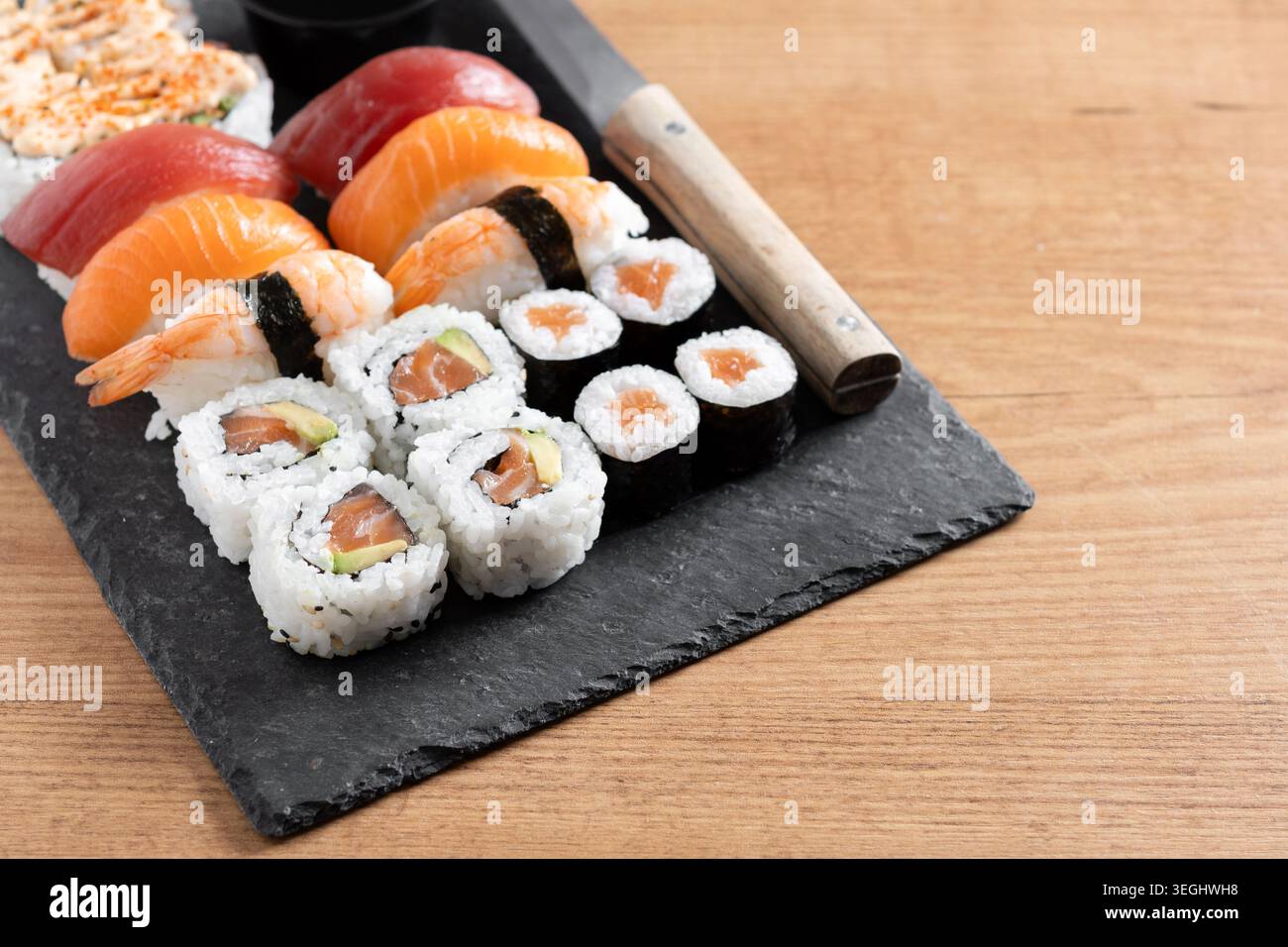 Frische Sushi-Auswahl mit Lachs Maki und Nigiri auf Holztisch Stockfoto