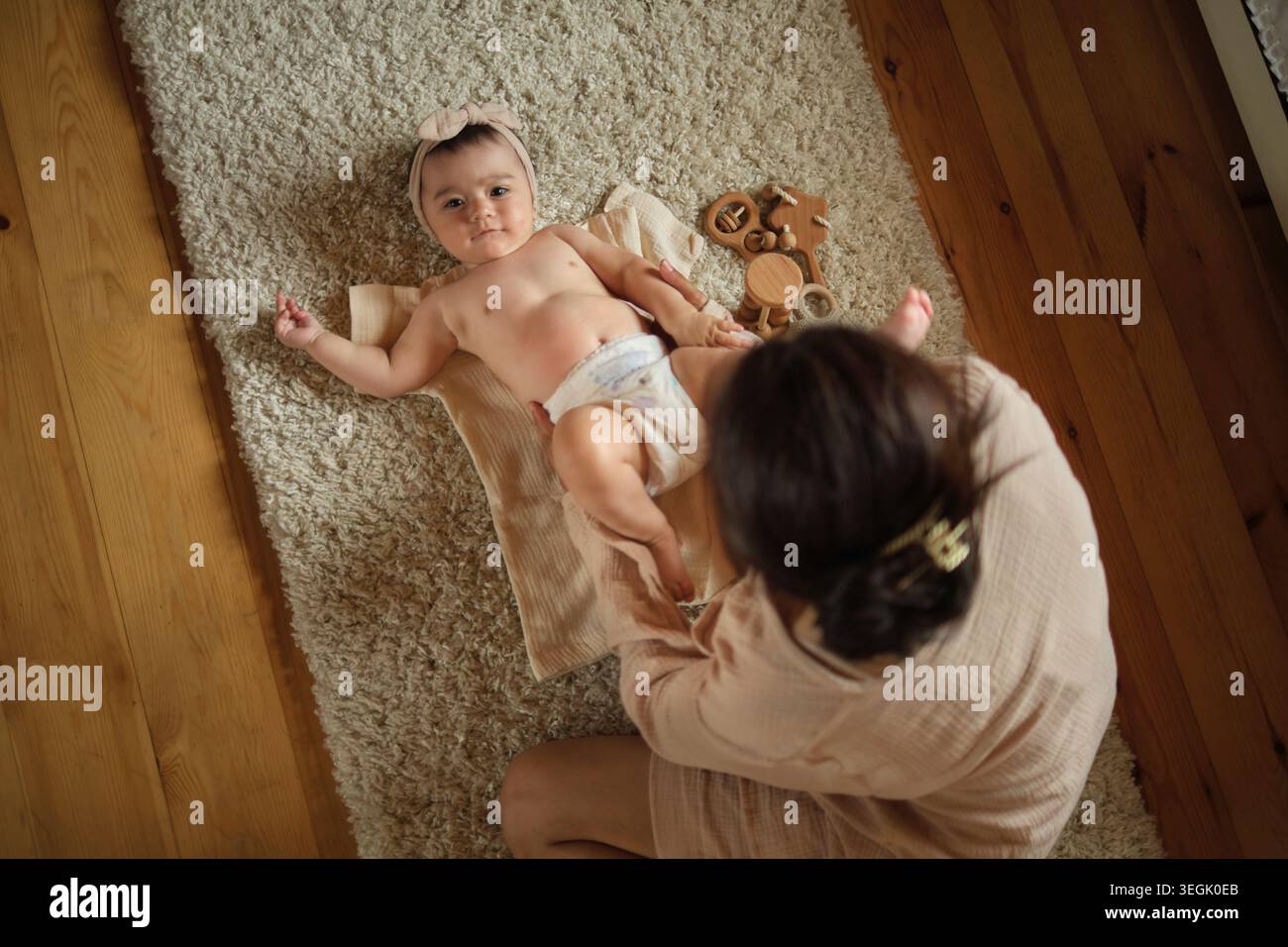 Gemütlichkeit und Sorgfalt prägen diese Szene, eine Mutter und ein Kind in einer ruhigen Kuschelei, umgeben von weichen Texturen. Zeigt den sanften Geist der Erziehung. Stockfoto