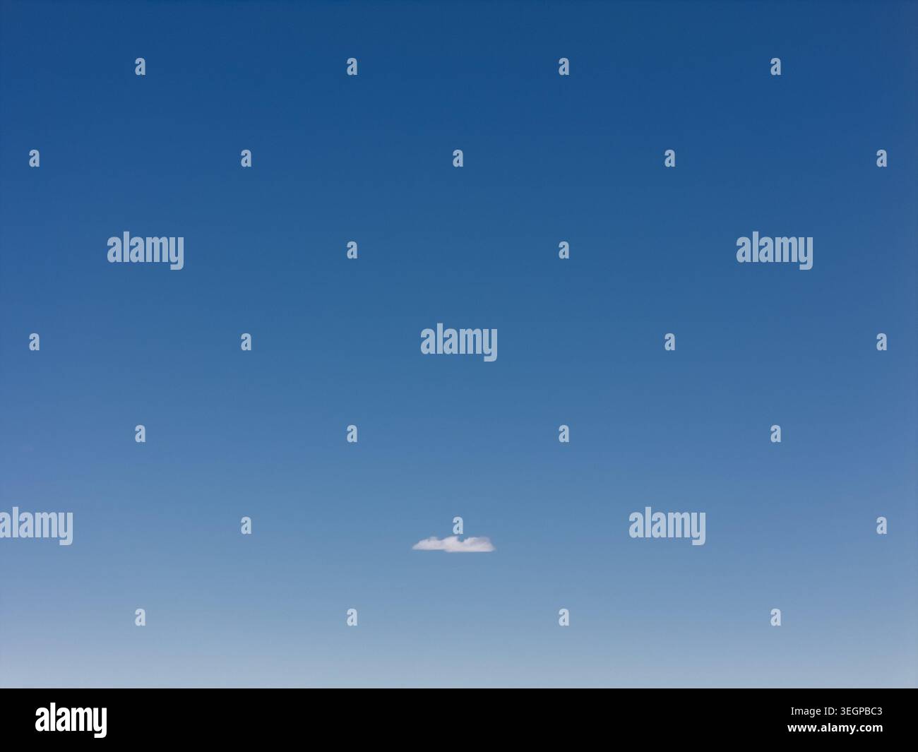 Blauer Himmel mit einer einzigen kleinen Wolke Stockfoto