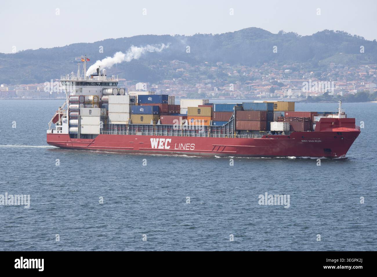 Rot-weißes Containerschiff der WEC Lines, beladen mit Fracht auf dem Wasser in Vigo, Spanien Stockfoto