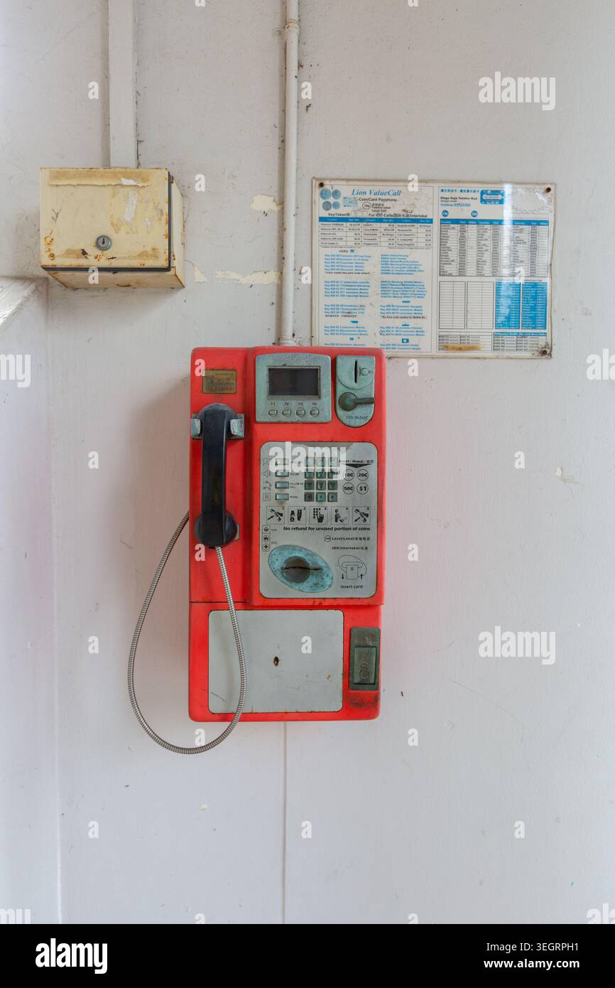 Vertikal. Altes öffentliches Münztelefon, um telefonieren zu können. Singapur. Stockfoto