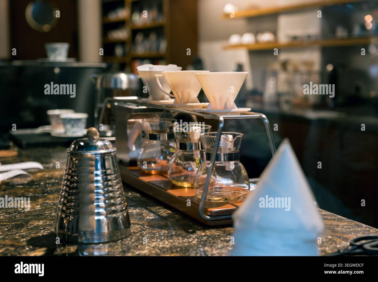Nahaufnahme eines raffinierten Kaffeegießens auf einem dunklen Granit-Café. Stockfoto
