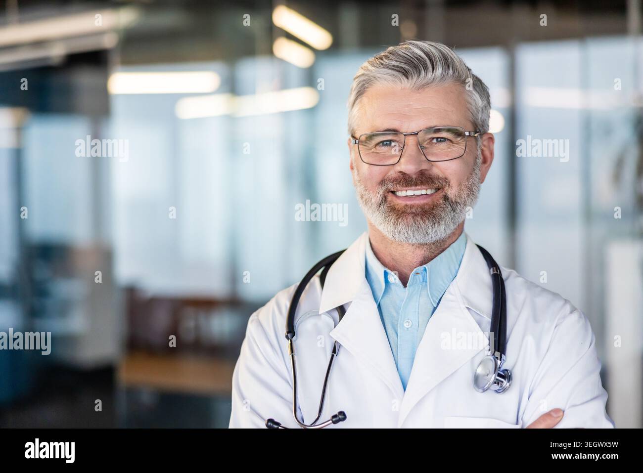 Ein reifer Arzt mit verschreibungspflichtiger Brille und weißem Mantel mit Stethoskop lächelt zuversichtlich und zeigt Expertise und Vertrauen in ein modernes Heil Stockfoto