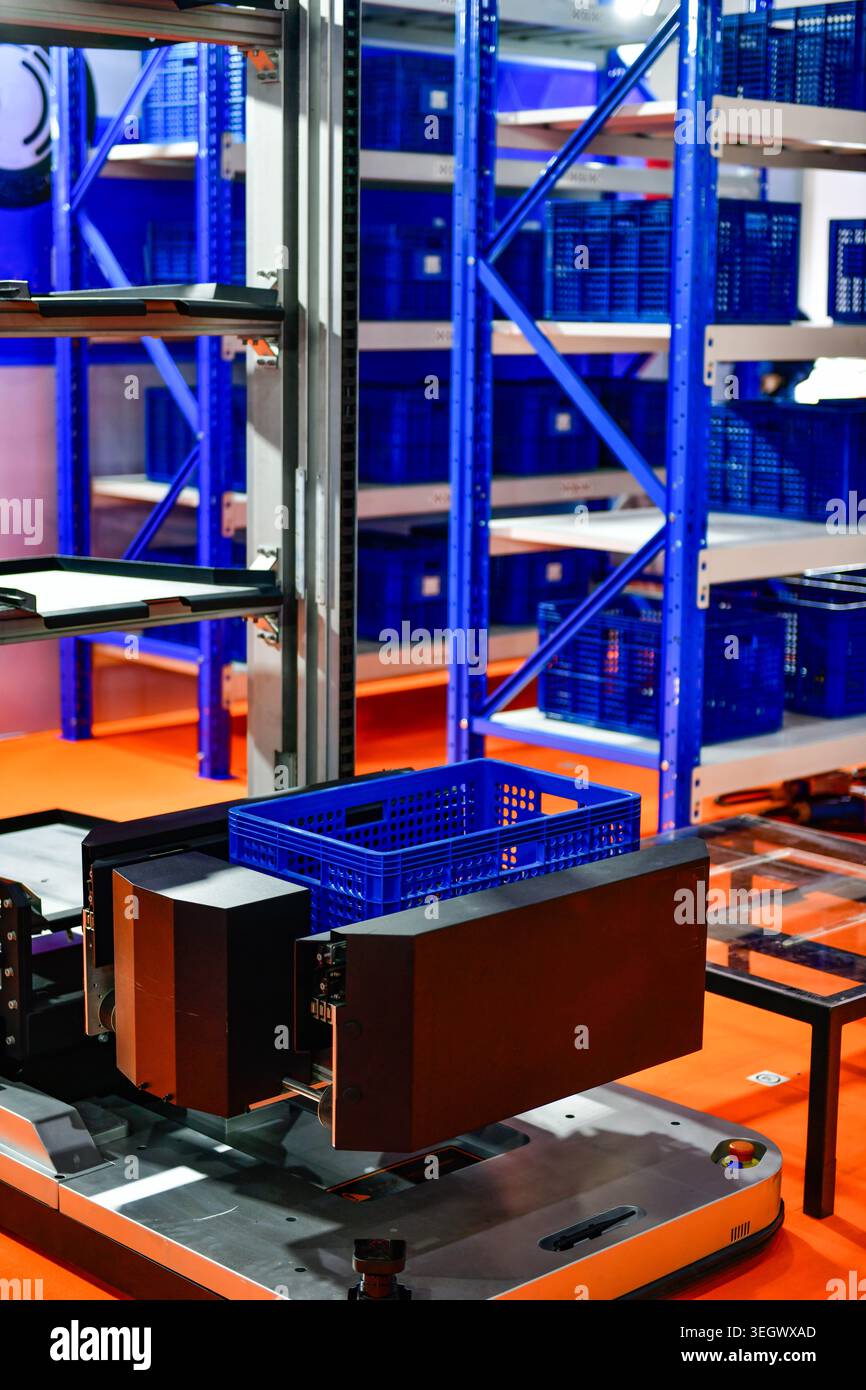 Autonome Robotermaschine mit Kunststoffbox in einem modernen Industrielager. Stockfoto