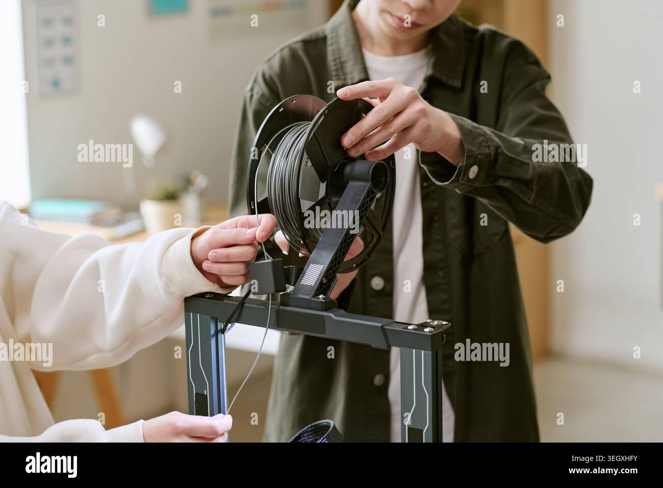 Teenager laden Filament auf 3D-Drucker für das MINT-Lernen Stockfoto