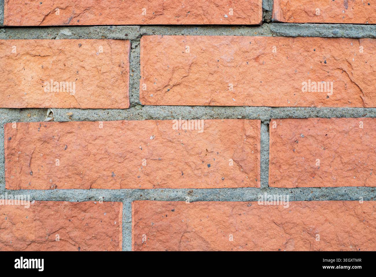 Rote Tonziegelwände. Raue Oberfläche einer traditionellen keramischen Blockstruktur. Langlebiges Baumaterial für Außenfassaden von Immobilien Stockfoto
