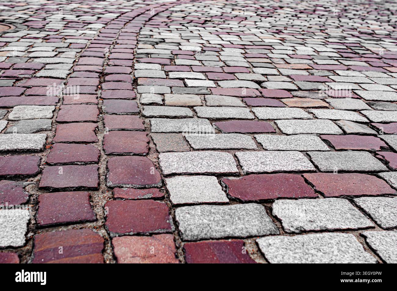Rote und graue Kopfsteinpflaster auf einer alten europäischen Straße. Stockfoto