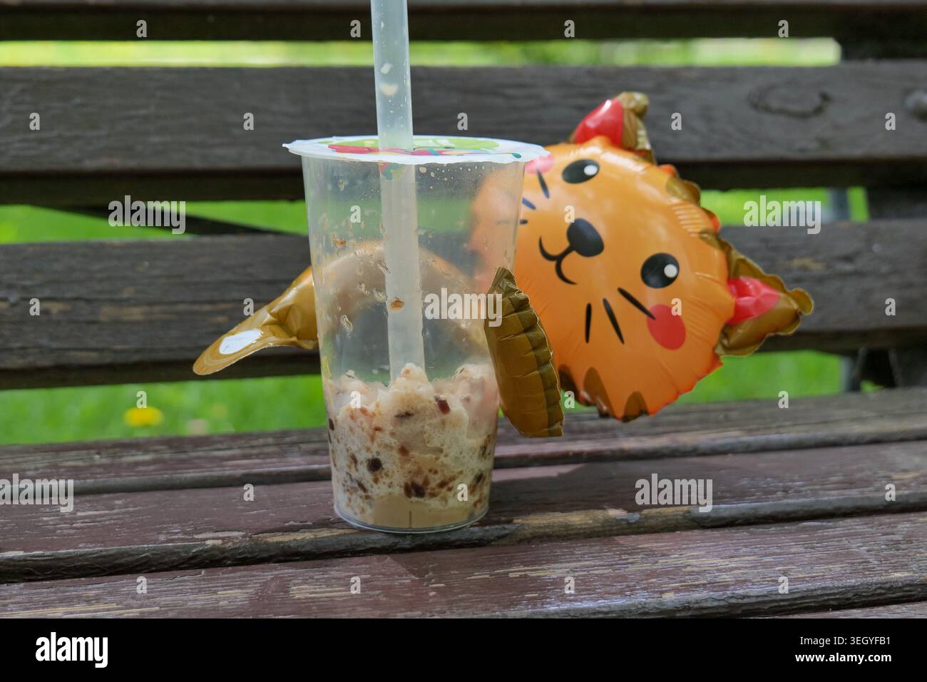 Bubble-Tee-Getränk mit einem katzenförmigen Ballon auf einer Holzbank Stockfoto