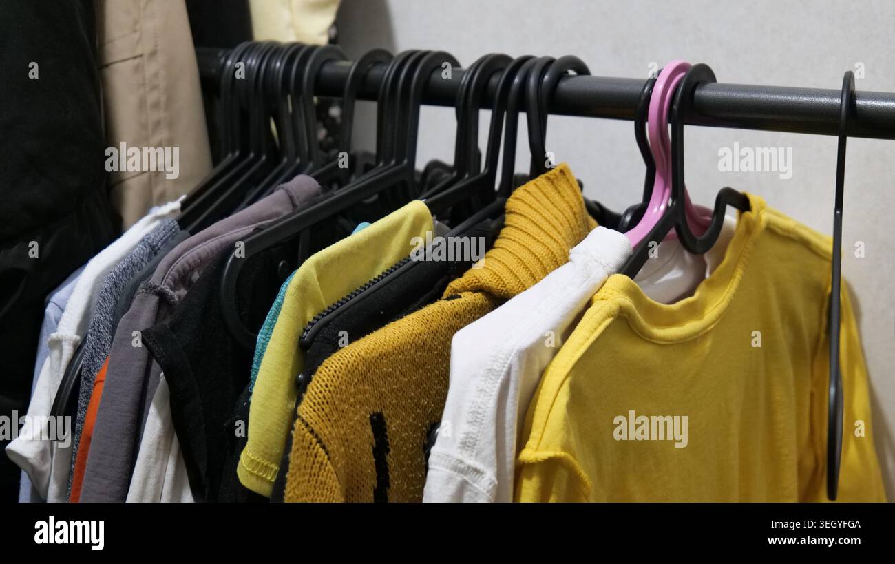 Bunte Kleidung auf hängenden Racks im Store Stockfoto
