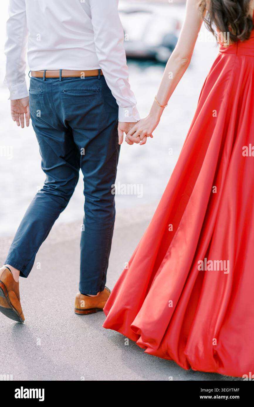 Elegantes Paar, das Hände am Wasser hält Stockfoto