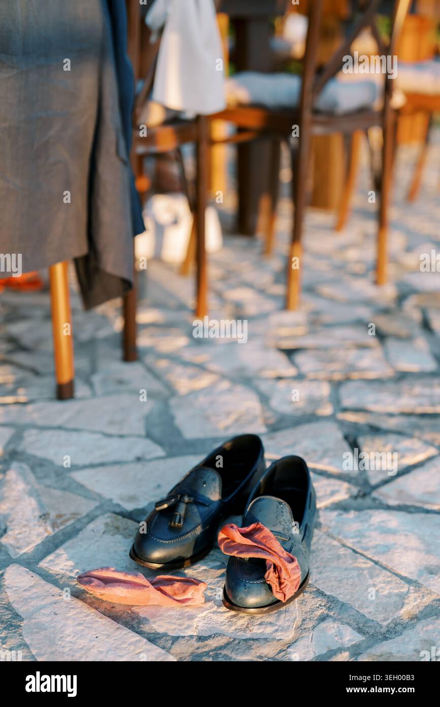 Blaue Loafers und rosafarbene Socken auf Steinpflaster bei Outdoor-Events Stockfoto