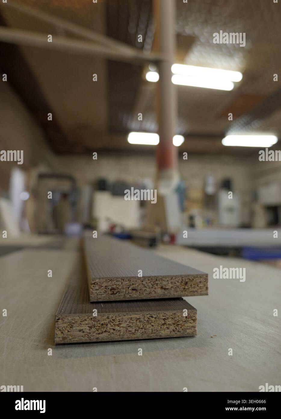 Zwei rohe Spanplatten mit braunen Laminatoberflächen werden in einer Holzbearbeitung gestapelt und zeigen Baumaterialien, die häufig für Furne verwendet werden Stockfoto